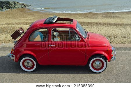 FELIXSTOWE, SUFFOLK, ENGLAND -  MAY 07, 2017: Classic Red Fiat 500  motor car with picnic basket parked on seafront promenade.