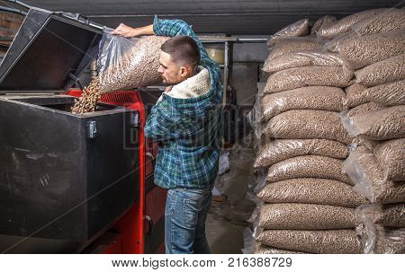 The Man Loads The Pellets In The Solid Fuel Boiler, Economical Heating