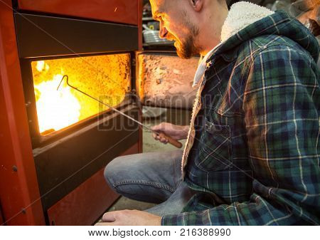 The Man Loads The Pellets In The Solid Fuel Boiler, Economical Heating
