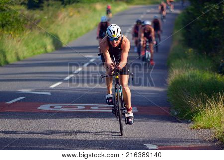 GRAFHAM, CAMBRIDGESHIRE, ENGLAND - AUGUST 06, 2017:  Female Triathlete on road cycling stage of triathlon.