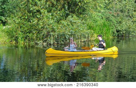 HEMMINGFORD GREY, CAMBRIDGESHIRE, ENGLAND - AUGUST 28, 2017:  People paddling in canoe on the river Ouse in Cambridgeshire.