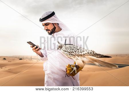Arabian man walking in the desert at sunrise