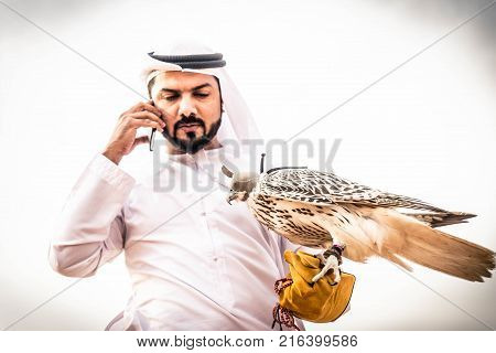 Arabian man walking in the desert at sunrise