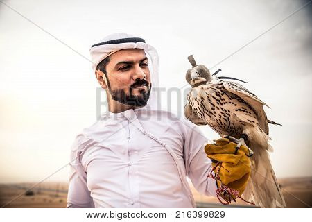 Arabian man walking in the desert at sunrise