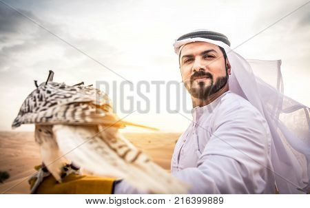 Arabian man walking in the desert at sunrise
