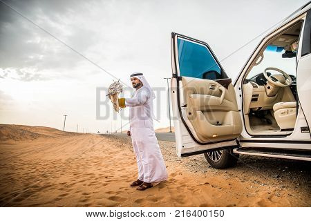 Arabian man walking in the desert at sunrise