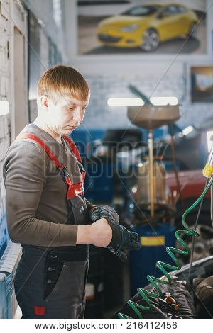 Mechanic works with voltmeter - car electrics - electrical wiring, close up