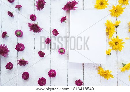 Multicolored flowers on a white wooden mocap background