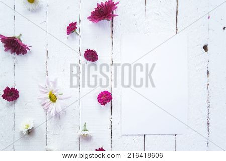 Multicolored flowers on a white wooden mocap background