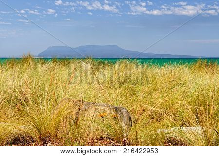 Maria Island as seen from behind the dune grass on Raspins Beach in Orford - Tasmania, Australia