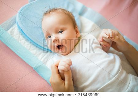 Happy newborn baby lying on the diaper and on the pillow