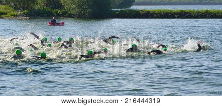 GRAFHAM, CAMBRIDGESHIRE, ENGLAND - MAY 21, 2017:  Competitors swimming at the beginning of the swimming stage of Triathlon.