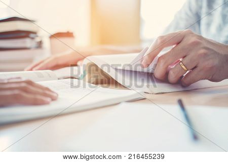 High School Or College Students Studying And Reading Together In Library