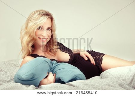 Pregnant young beauty awaiting her newborn while relaxing in bed at home