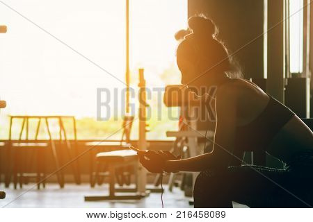 Healthy woman relaxing after exercise and listen music after the workout.