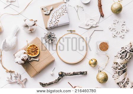 Flat lay top view photo of a mockup with an embroidery hoop and Christmas de. Stylish feminine new year layout composition.
