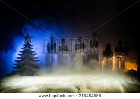 Electronic Cigarette With Vape Liquids And Christmas Decorations On Bokeh Lights Background