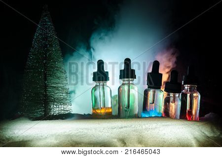 Electronic Cigarette With Vape Liquids And Christmas Decorations On Bokeh Lights Background