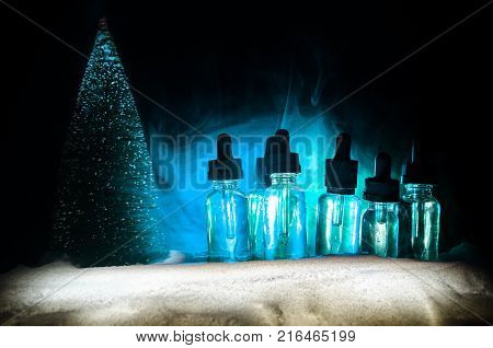 Electronic Cigarette With Vape Liquids And Christmas Decorations On Bokeh Lights Background