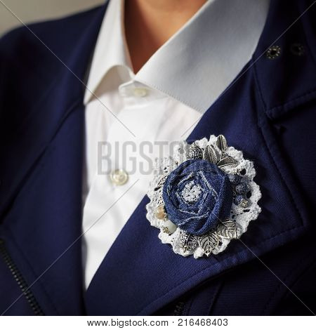 Brooch handmade in the form of a flower from denim as additional accessory of a woman business suit