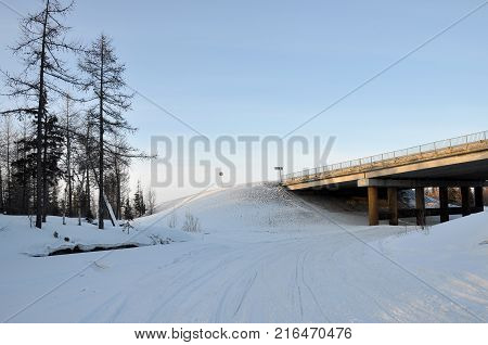 Winter bridge over the frosty and snowy river