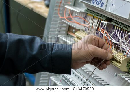 Electrician Assembling Industrial Hvac Control Cubicle In Workshop. Close-up Photo.