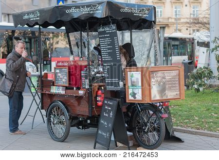 Brno,Czech Republic-November 27,2017: Man drinks coffe in front of Mobile coffeebike at Christmas market at Moravian Square on November 27, 2017 Brno, Czech Republic