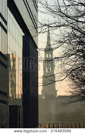 Cityscape of Hamburg. Silhouette of the St. Catherine Church through the elements of a modern building in downtown of Hamburg.
