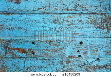 Grunge background texture of blue painted brown wood with dirty stains, scratches, wholes and cracks