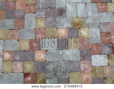 Background of street road colorful stone paving of multicolor bricks, close up, high angle view