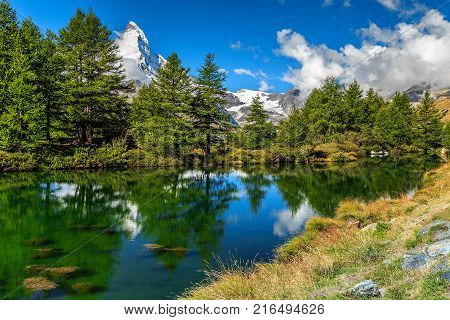 Green alpine oasis with the Grindjisee lake and snowy Matterhorn peak, glaciers in background, Zermatt, Valais region, Switzerland, Europe