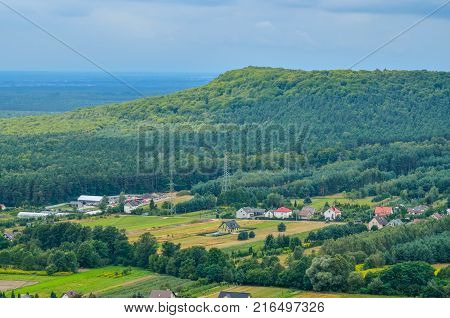 Summer rural landscape. Homes in the countryside among the green hills.