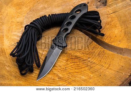 The folding knife is black and the parachute cord.