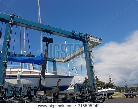 Marina hardstand travel lift with yacht hoisted for maintenance