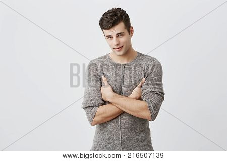 Portrait of serious handsome man with appealing expression, keeps arms folded, tries to be strict. Muscular fit stylish male student being dissatisfied with final mark, demands to retake exam