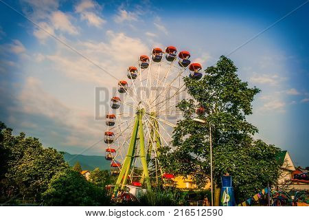 Old Ferris wheel in the city park of attractions. Toning