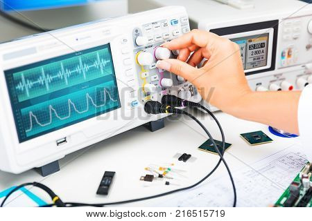 Digital oscilloscope is used by an experienced electronic engineer in the laboratory