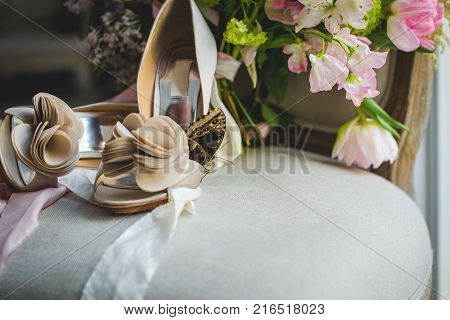 The bride on her wedding day. Morning bride. Wedding accessories. Wedding bouquet into basket. String of pearls