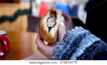 Closeup View Female Hands Holding German Sausage Bockwurst at Christmas Market.