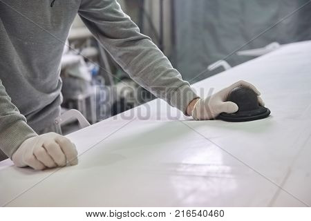 Man is polishing white plate. Plane polishing.