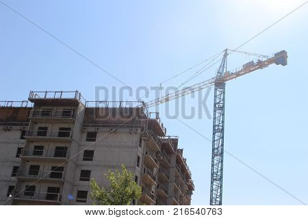 Apartment building being constructed with a large crane