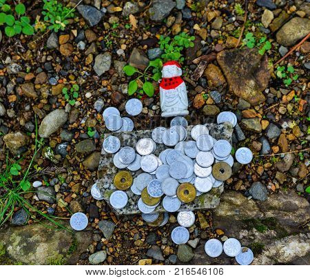 Small Buddha with praying coins on Mt. Koya in Wakayama Japan. Mount Koya (Koya-san in Japanese) is one of Japan most sacred mountains.