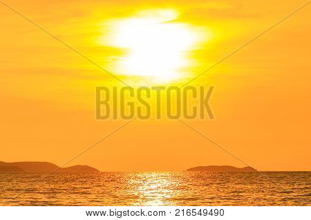 Dramatic sky at sunset or evening time over sea or ocean with golden or orange light tone.