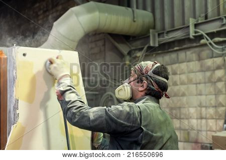 Lipetsk, Russia - June 15, 2017: Lipetsk Machine Tool Plant. The worker polishes the primer layer. Work on the preparation of the machine bed for subsequent painting.