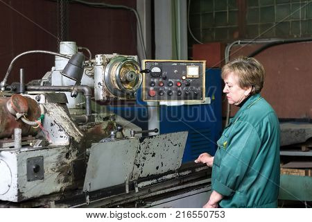 Lipetsk, Russia - June 15, 2017: Lipetsk Machine Tool Plant. A woman works on an internal grinding machine. Stage of metal finishing of parts.