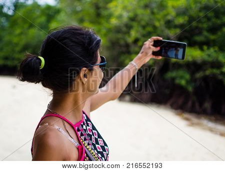 Girl Taking a Picture of Self on a Beach