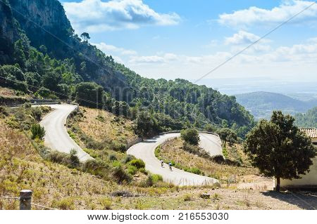 Cyclists climb the serpentine mountain road in the Sierra of Tramontana, Mallorca