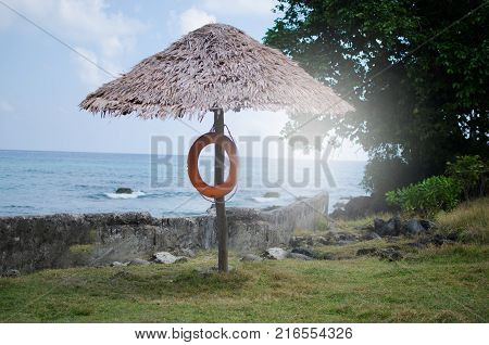 Parasol Umbrella at a Beach with Blue Sky and Setting Sun