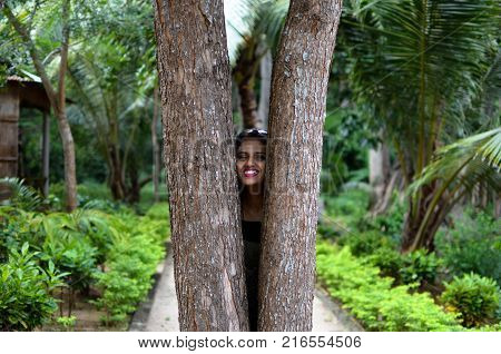 Girl Peeking Through The Woods or Two Trees