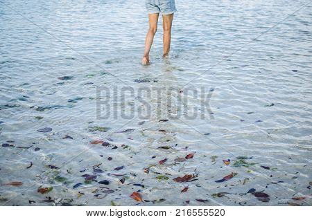 Legs with Footprints on Sand. Inside water till ankle.
